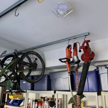 yard tools hanging on sliding bike rack