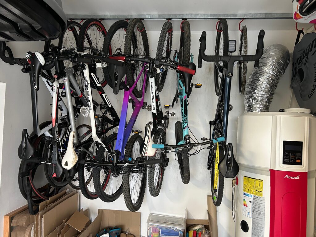 A signle strut channel with bikes hanging near a water heater, using standard size hooks