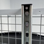 Close up of a strut channel and GearBlocks endcap hanging  under a white spider rack.